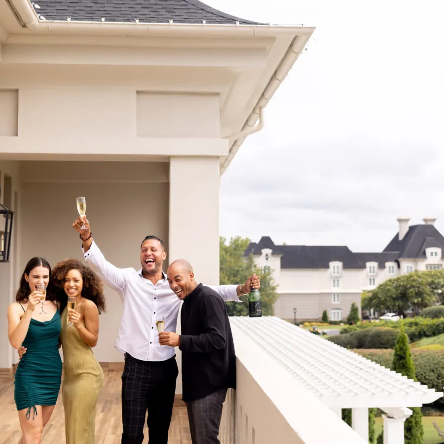 A group of people posing for a photo on a balcony.