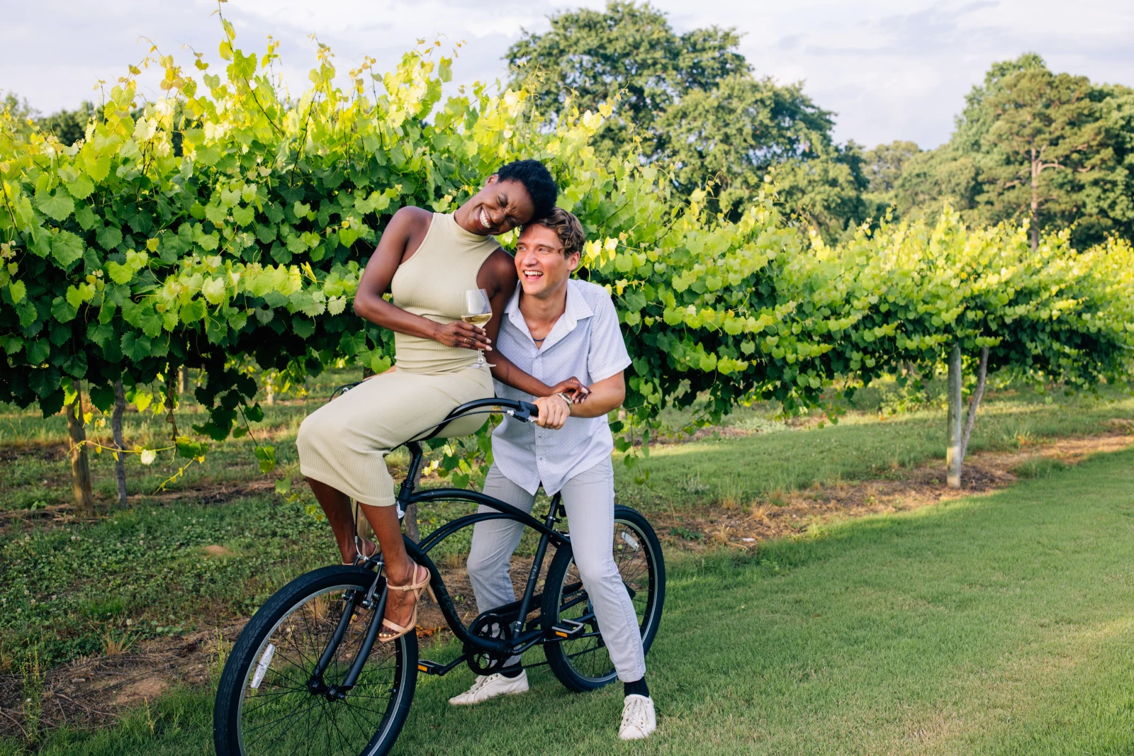 Couple riding bicycle through vineyard