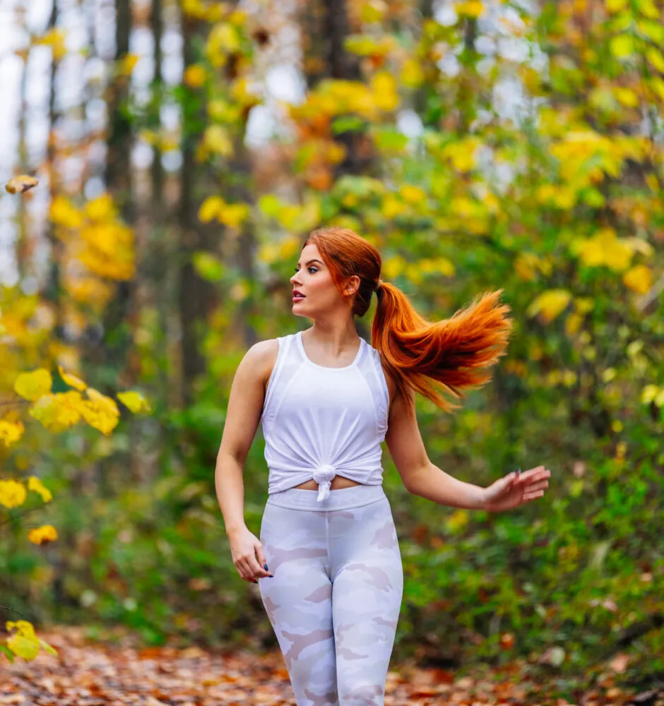 Woman walking on forest trail in autumn