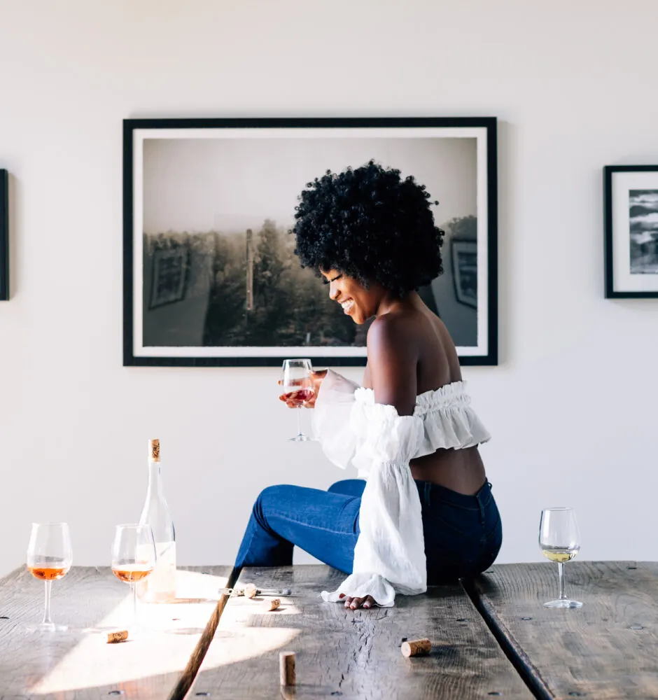 A person looks at artwork hanging on a wall in a bright room.