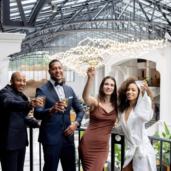 A group of people cheering with glasses in a formal setting.