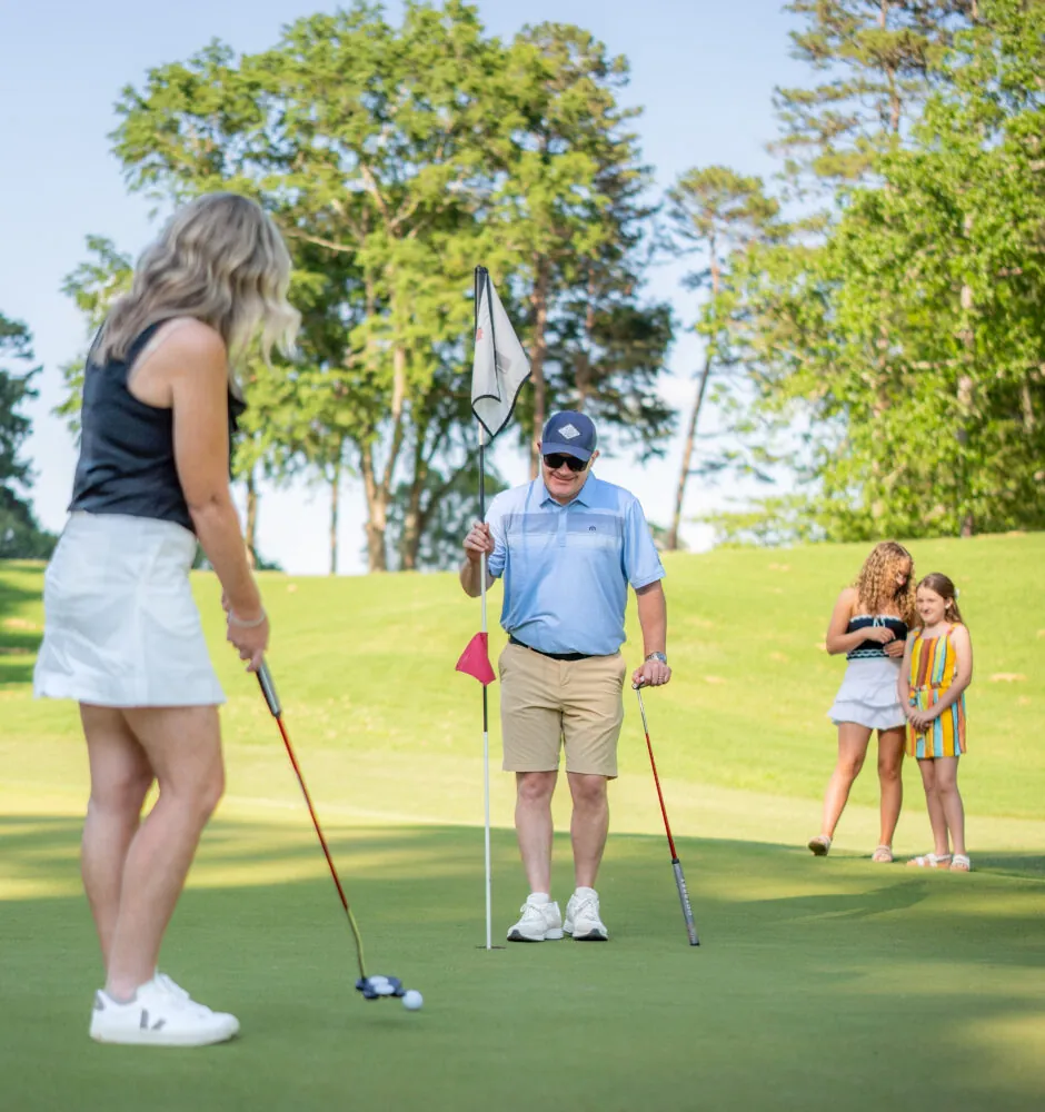 A family playing golf together on a green.