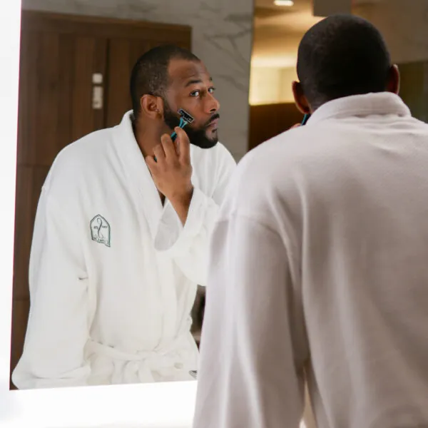 Man in robe looking in spa mirror