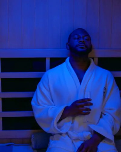 Man relaxing in sauna with blue lighting