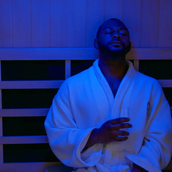 Man relaxing in sauna with blue lighting