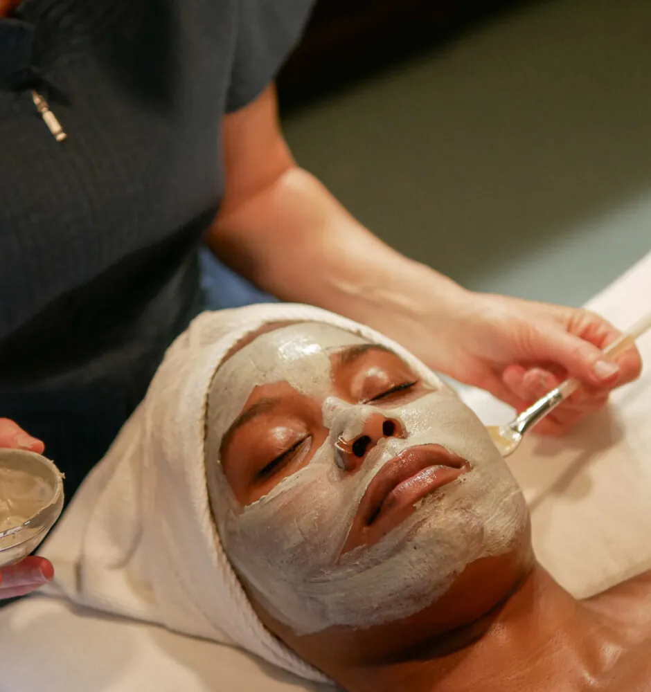 Person receiving a facial mask treatment at spa