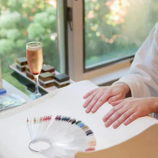 Hands selecting nail polish colors at spa