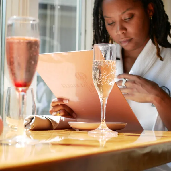 Woman reading menu with champagne at table