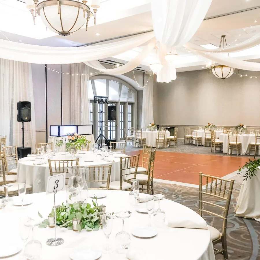A reception hall with round tables set up for a meal.