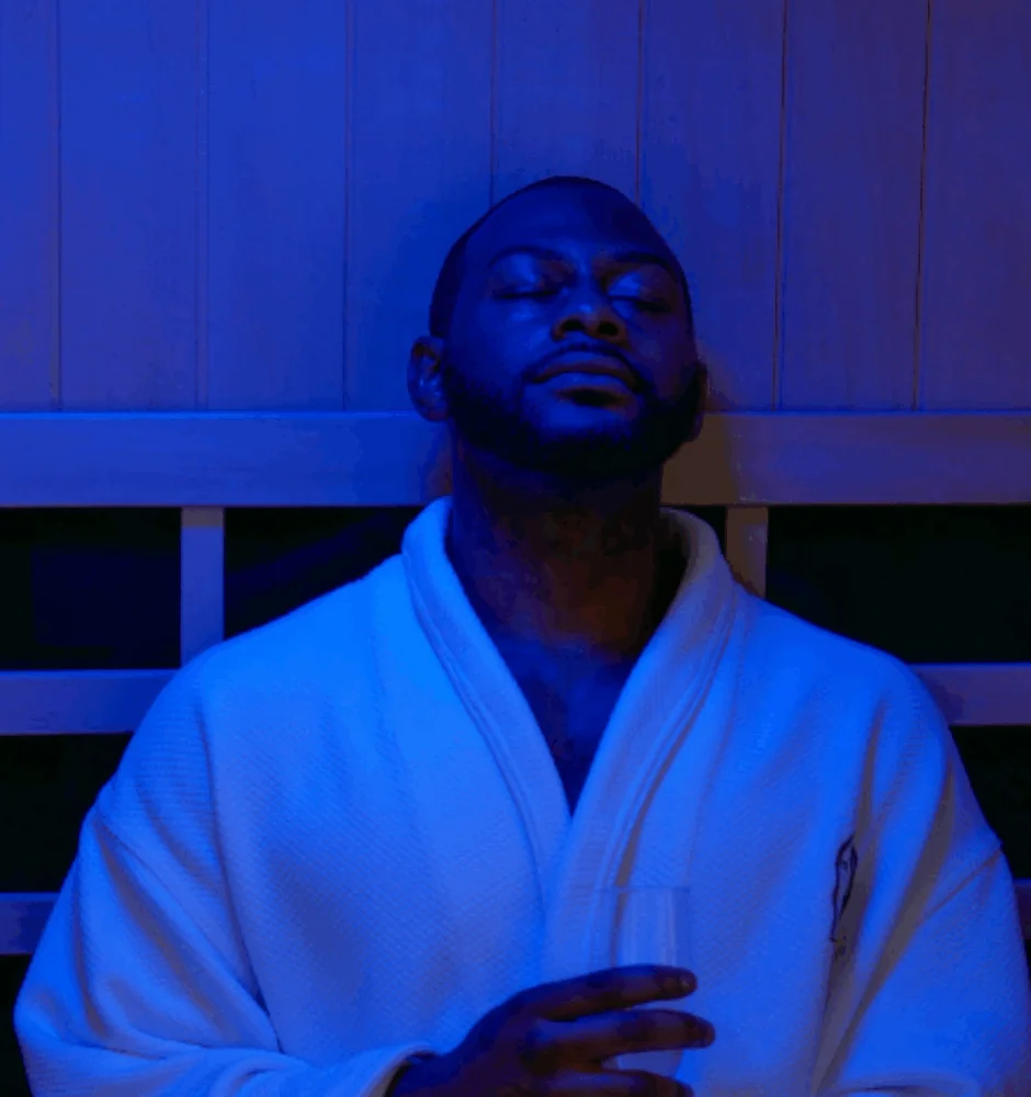 Man relaxing in a sauna wearing a robe