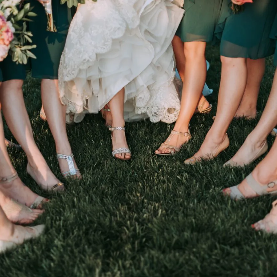 A shot of a group of people's feet on a dark, patterned carpet.